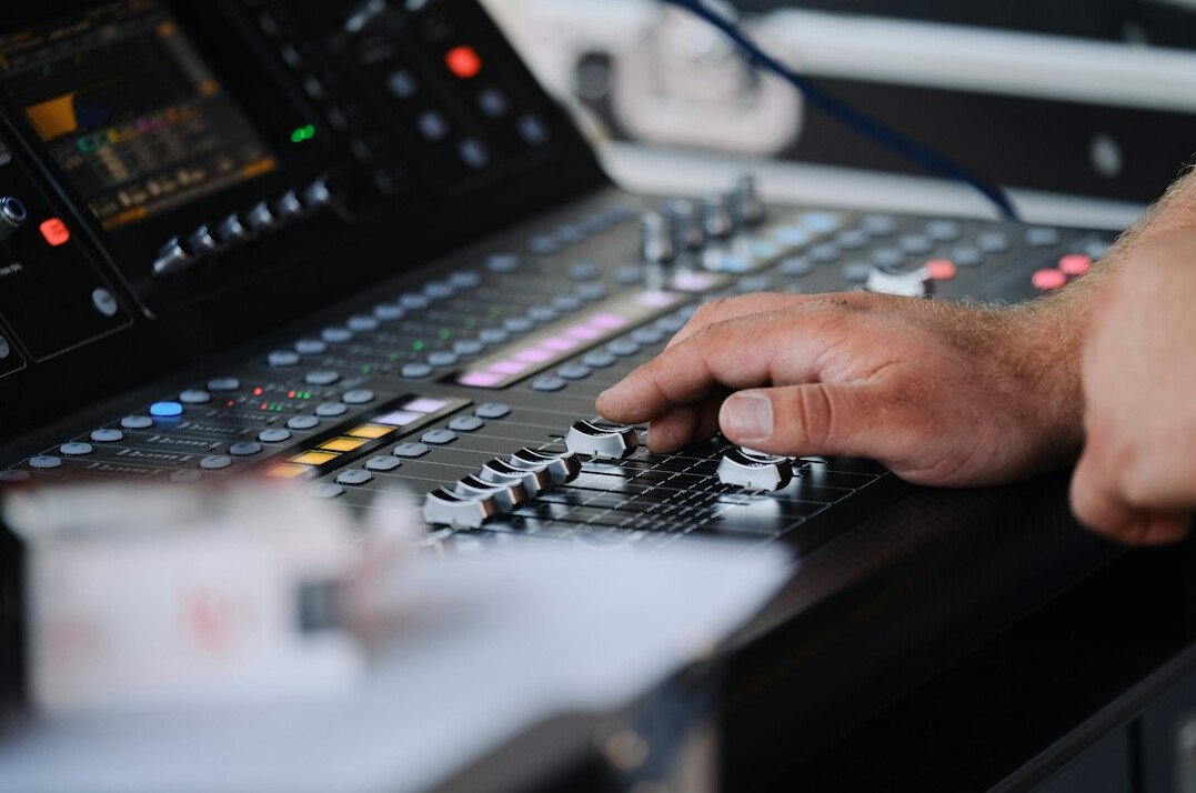 person adjusting audio mixer